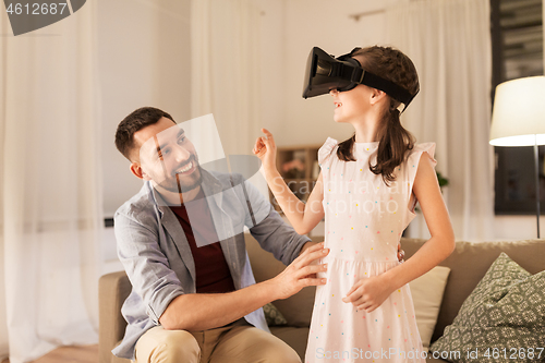 Image of father and daughter in vr glasses playing at home