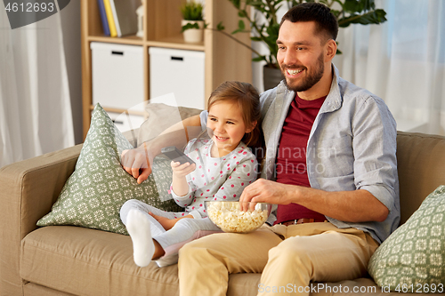 Image of happy father and daughter watching tv at home