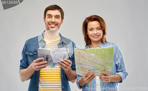 Image of happy couple of tourists with city guide and map