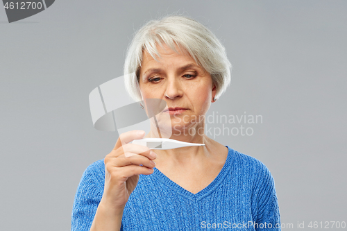 Image of sick senior woman with thermometer