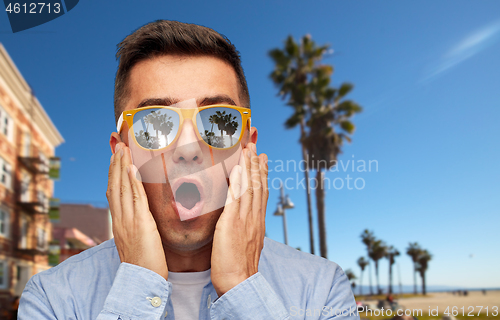 Image of surprised man in sunglasses over venice beach