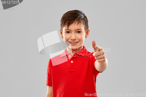 Image of smiling boy in red t-shirt pointing finger to you