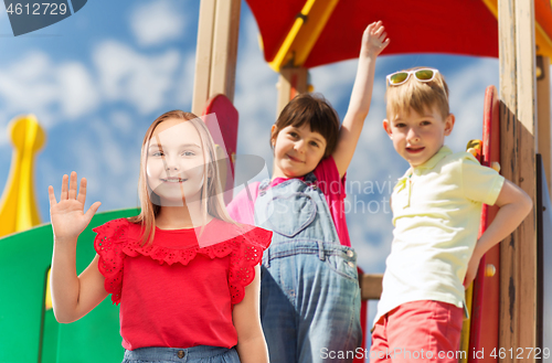 Image of smiling girl waving hand on kids playground