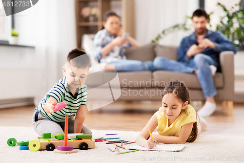 Image of brother and sister playing and drawing at home