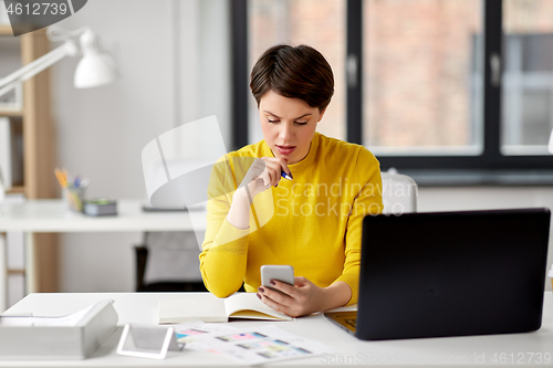 Image of smiling ui designer using smartphone at office