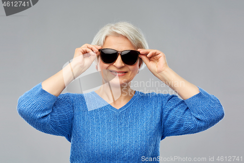 Image of smiling senior woman in black sunglasses