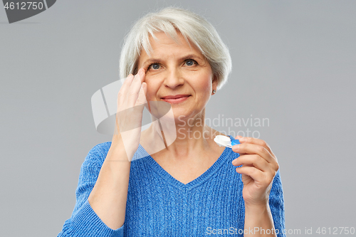 Image of senior woman applying contact lenses