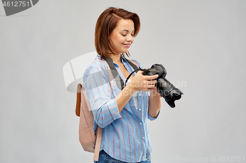 Image of happy tourist woman with backpack and camera