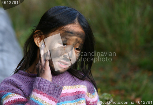 Image of Portrait of a young cute girl looking at the camera putting coal
