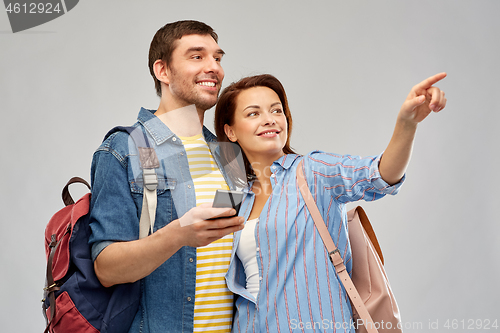 Image of happy couple of tourists with smartphone