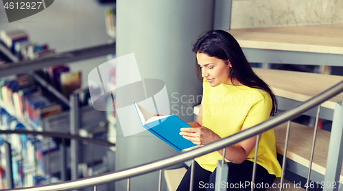 Image of high school student girl reading book at library