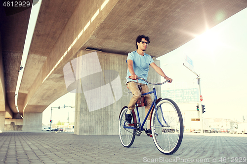 Image of young hipster man riding fixed gear bike