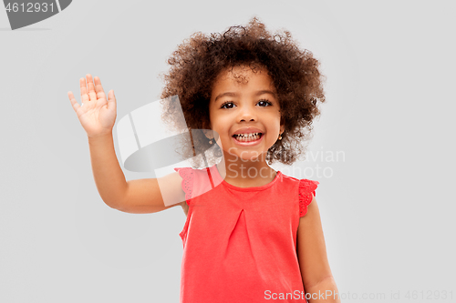 Image of happy little african american girl waving hand