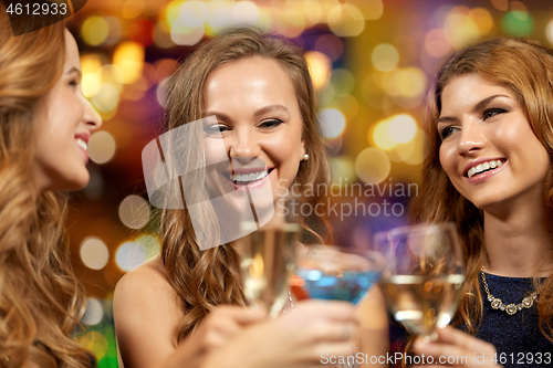 Image of happy women clinking glasses at night club