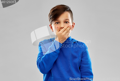 Image of shocked boy closing mouth by hand