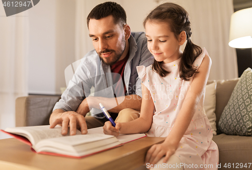 Image of father and daughter doing homework together