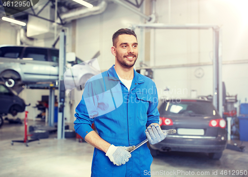 Image of auto mechanic or smith with wrench at car workshop