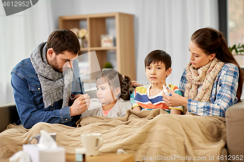 Image of family with medicine treating ill children at home