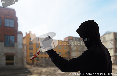 Image of close up of criminal with blood on knife