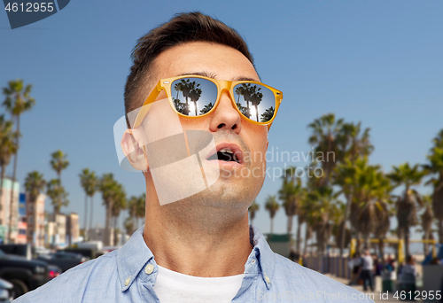 Image of surprised man in sunglasses over venice beach