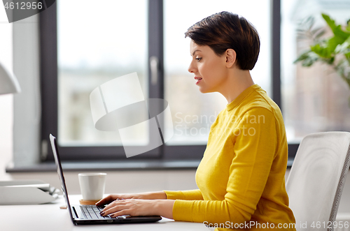 Image of businesswoman with laptop working at office