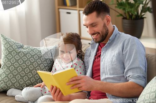 Image of happy father and daughter reading book at home