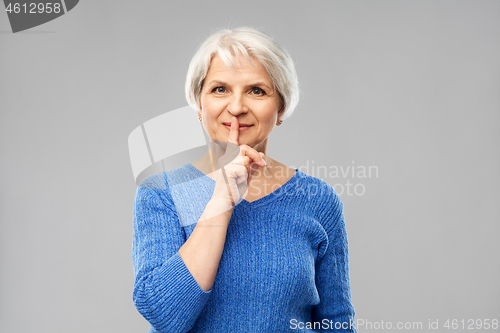 Image of senior woman making shush gesture