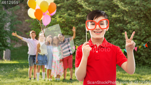 Image of boy with glasses showing peace at birthday party