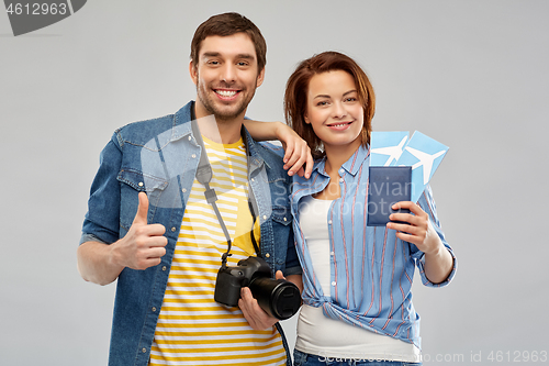 Image of happy couple with air tickets, passport and camera