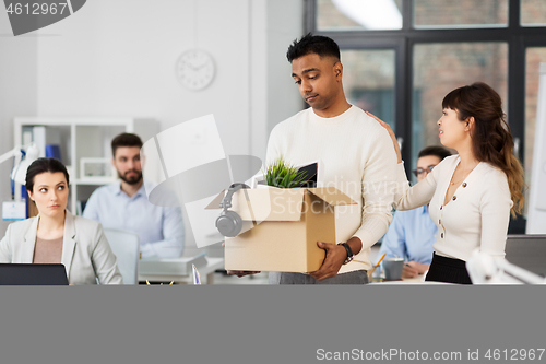 Image of colleague seeing off sad fired male office worker