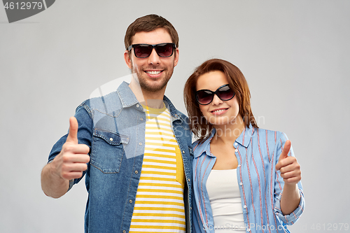 Image of happy couple in sunglasses showing thumbs up