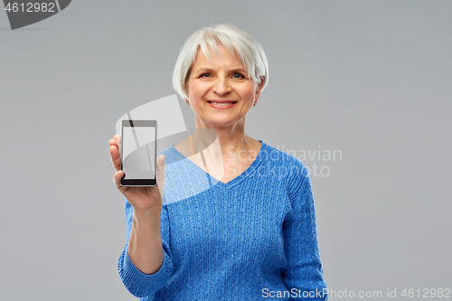 Image of smiling senior woman showing smartphone