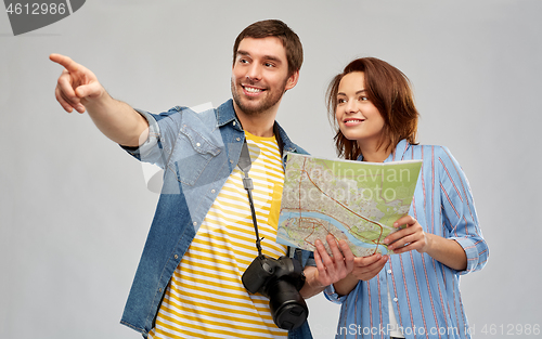 Image of happy couple of tourists with map and camera