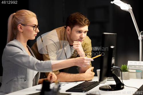 Image of business team with computer at night office