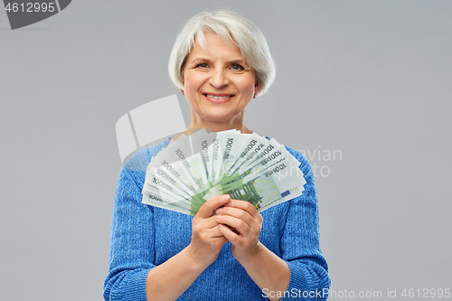 Image of senior woman with hundreds of euro money banknotes