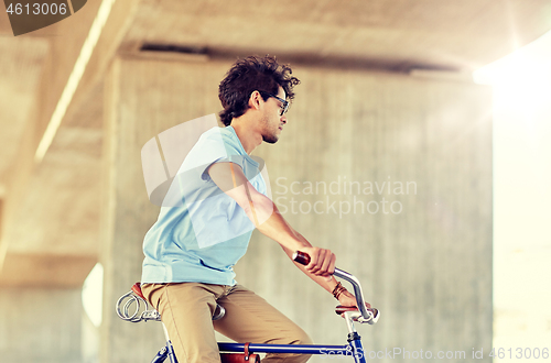 Image of hipster man riding fixed gear bike