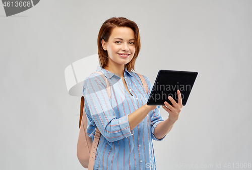 Image of happy woman with backpack and tablet computer