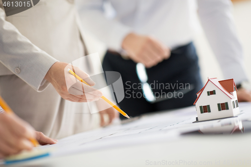 Image of close up of architects with blueprint at office