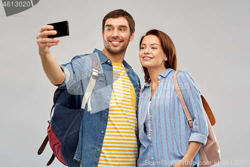 Image of couple of tourists taking selfie by smartphone