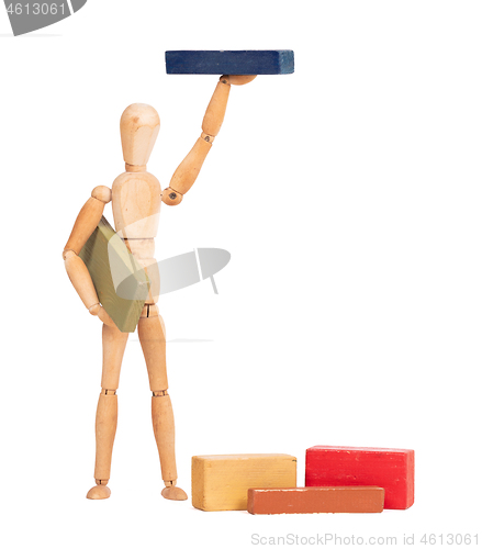 Image of Wooden mannequin carrying a wooden block