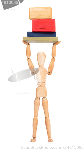 Image of Wooden mannequin carrying wooden blocks