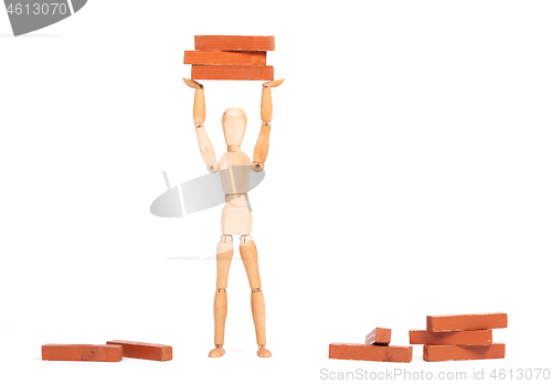 Image of Wooden mannequin carrying wooden blocks