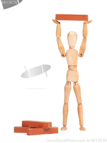 Image of Wooden mannequin carrying a wooden block