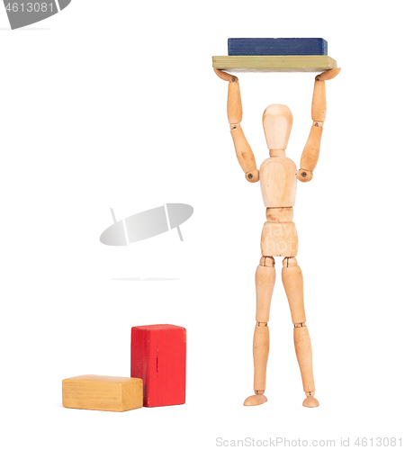 Image of Wooden mannequin carrying wooden blocks