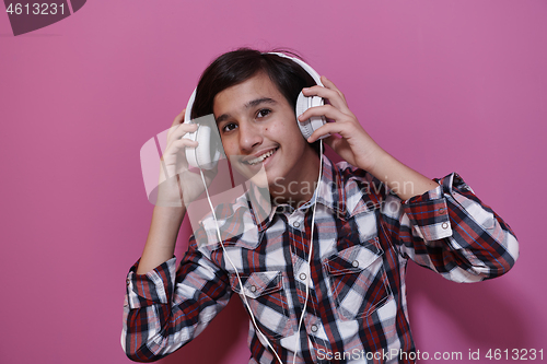 Image of Arab Teenage Boy Wearing Headphones And Listening To Music