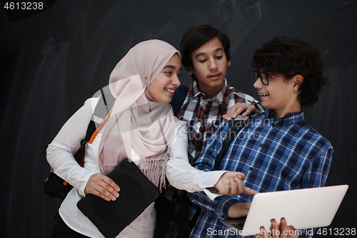 Image of Arab teenagers group working on laptop and tablet computer