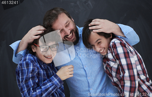 Image of happy father hugging sons