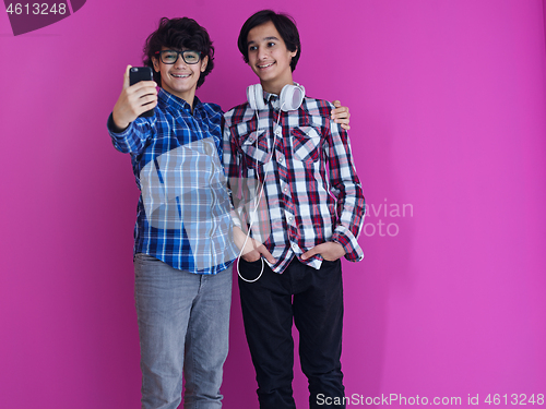 Image of Arab teenagers  against pink wall