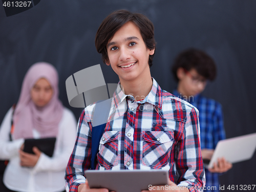 Image of Arab teenagers group working on laptop and tablet computer