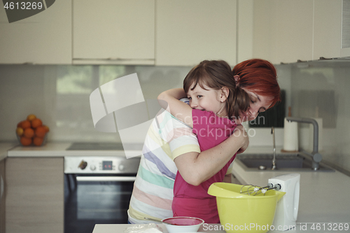 Image of Mother and daughter playing and preparing dough in the kitchen.